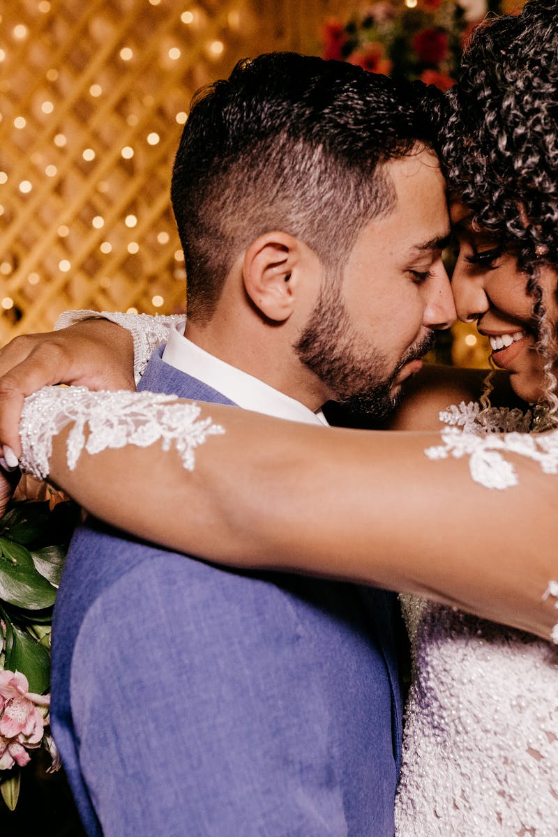 Romantic moment of bride and groom embracing indoors at their wedding ceremony.